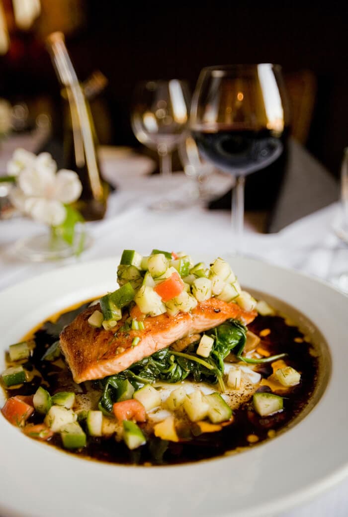 A plated course with a glass of red wine
